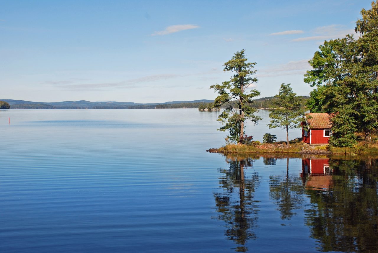 Röd stuga vid sjön